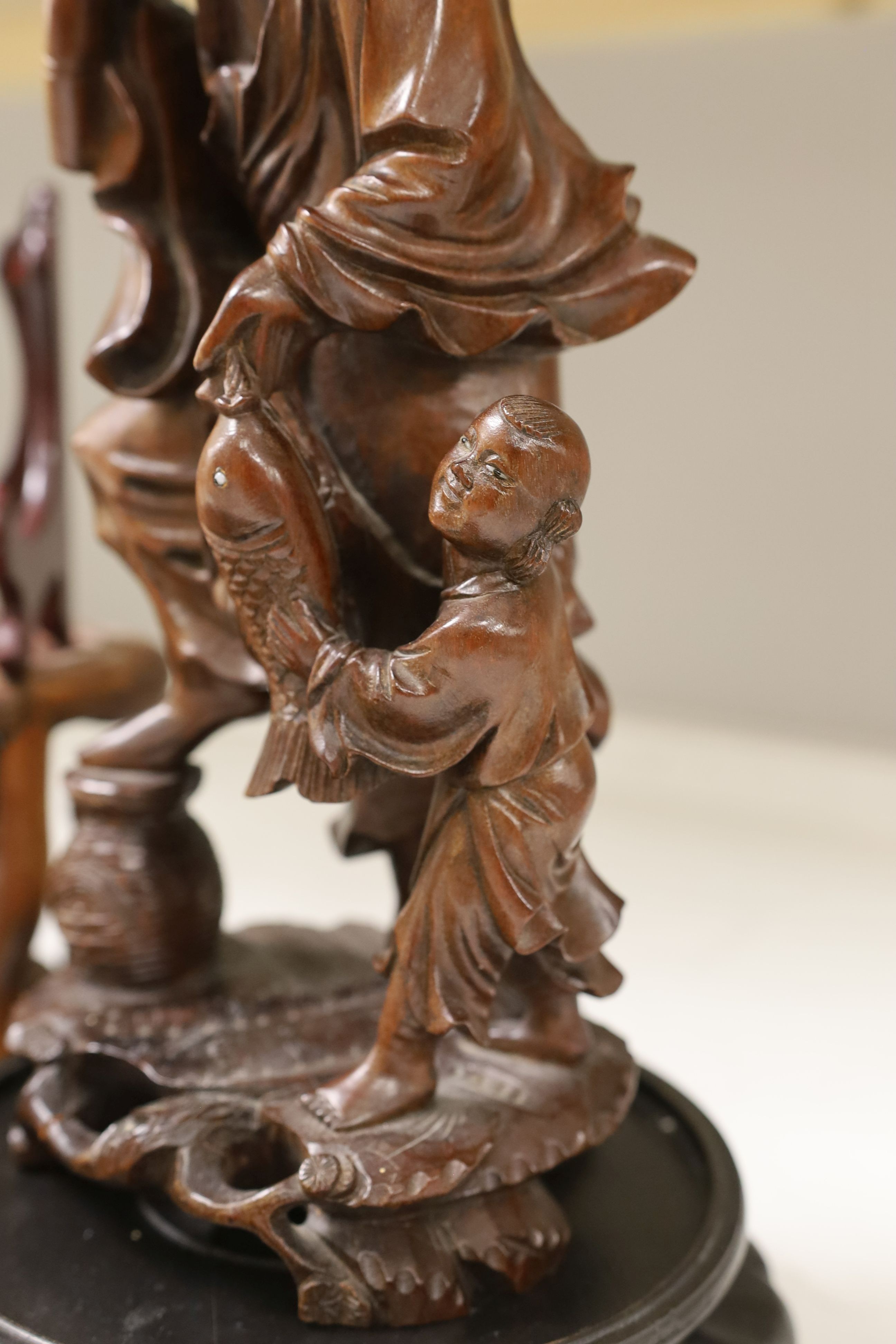 A Chinese hardwood figure of fisherman, 42cm tall including stand, and a quantity of wooden stands